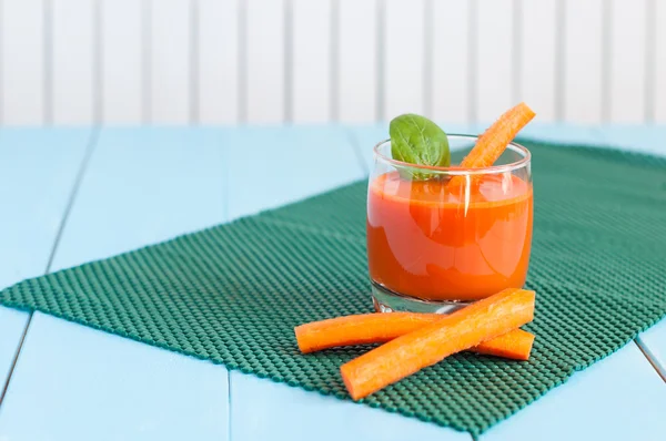 Jugo de zanahoria casero saludable en vaso y zanahorias frescas sobre fondo de madera clara . — Foto de Stock