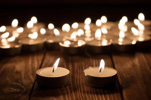 Pareja de velas y velas borrosas sobre fondo de madera viejo — Foto de Stock