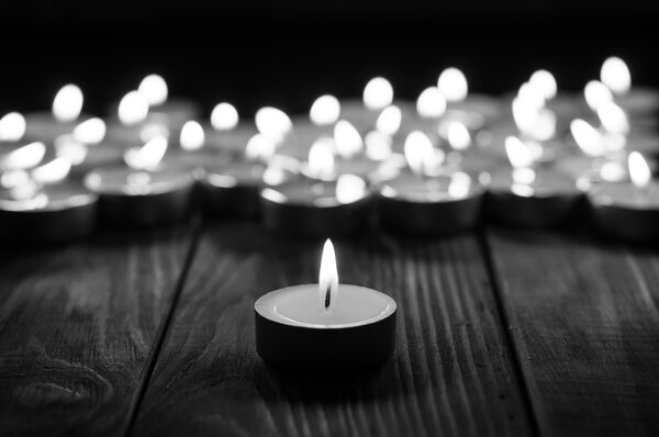 Uma vela e velas no fundo de madeira velho — Fotografia de Stock
