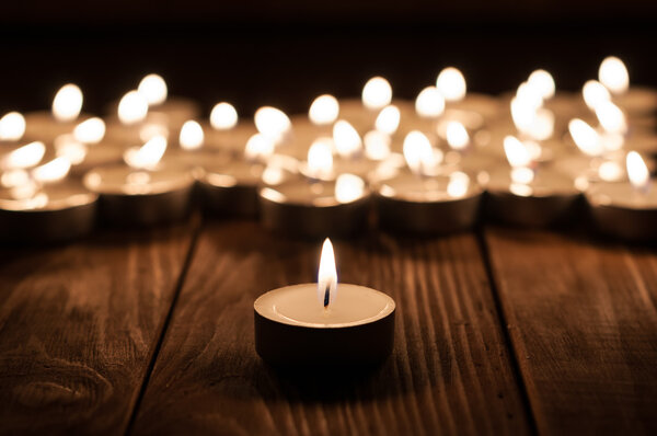 Uma vela e velas no fundo de madeira velho — Fotografia de Stock
