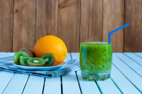 Υγιεινό σπιτικό ακτινίδιο χυμό στο ποτήρι και φρέσκο πορτοκάλι, ακτινίδιο σε ελαφριά ξύλινα φόντο. — Φωτογραφία Αρχείου