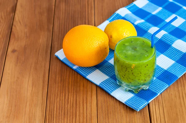 Υγιεινό σπιτικό ακτινίδιο χυμό στο ποτήρι και φρέσκο πορτοκάλι, ακτινίδιο σε ξύλινα φόντο. — Φωτογραφία Αρχείου