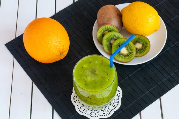 Вкусный ассортимент свежих фруктовых соков подается в высоком бокале из ликвидированных киви и апельсина, лимон для здорового летнего угощения богатые витамины — стоковое фото