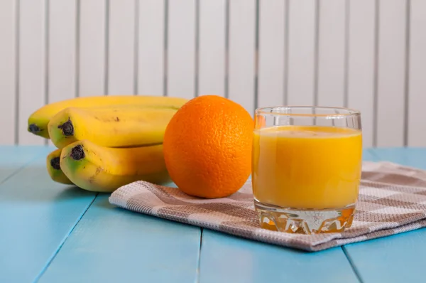 Zumo de naranja en vaso, frutas frescas sobre fondo de madera —  Fotos de Stock