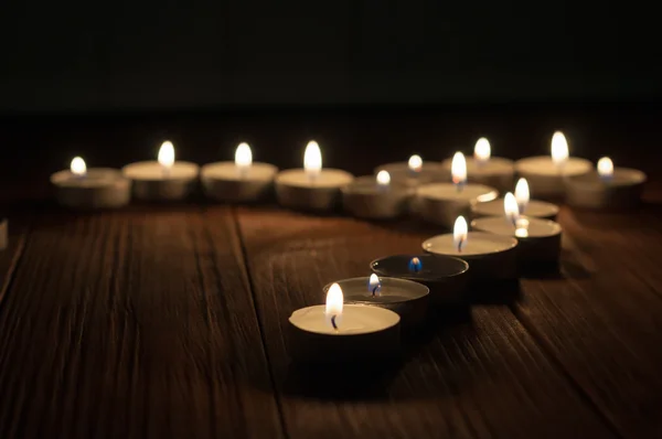 Una candela e candele su vecchio sfondo di legno — Foto Stock