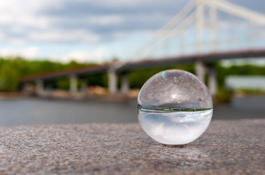 Glass transparent ball on bridge background and grainy surface. With empty space clipart
