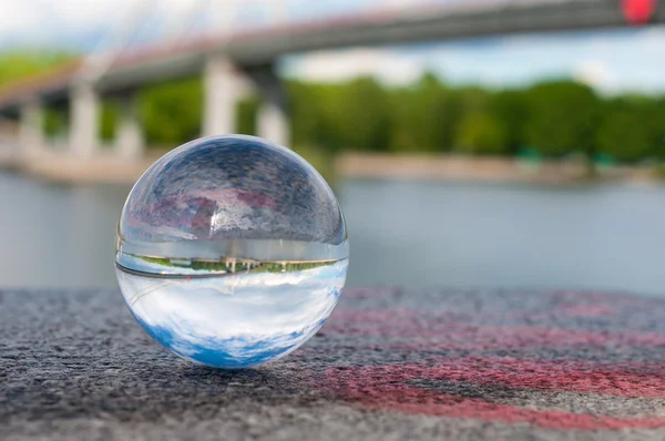 Γυάλινα διαφανή μπάλα στην γέφυρα φόντο και κοκκώδη επιφάνεια. Με κενό χώρο — Φωτογραφία Αρχείου