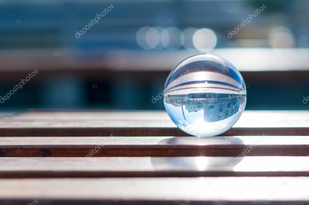 Glass transparent ball on wooden slats background. With empty space