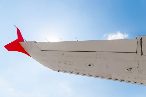 Ala del avión en el fondo del cielo azul, vista bajo el avión —  Fotos de Stock