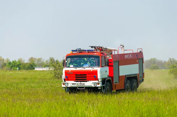 BORYSPIL, UKRAINE - MAIO, 20, 2015: Bombeiros em caminhão de bombeiros Tatra montam em alarme para instrução para supressão de incêndio e assistência às vítimas de minas no Aeroporto Internacional de Boryspil, Kiev, Ucrânia . — Fotografia de Stock