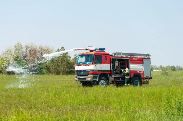 BORYSPIL, UCRANIA - 20 DE MAYO DE 2015: Brigada de bomberos en Fire Engine Mercedes utilizando un cañón de agua durante un evento de entrenamiento en el Aeropuerto Internacional de Boryspil, Kiev, Ucrania . —  Fotos de Stock