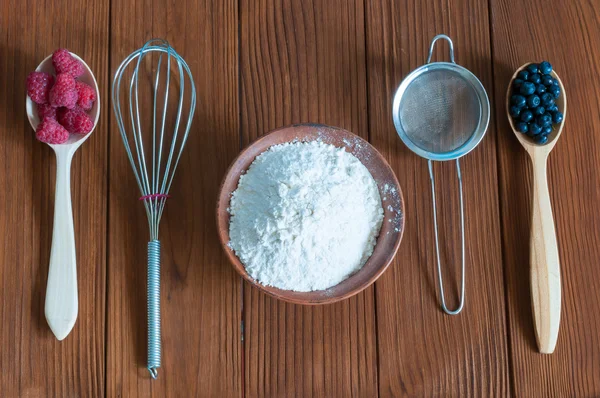 Ingredients for cooking berry cake. Raspberries, blueberries and flour in bowl on dark wooden background — Φωτογραφία Αρχείου