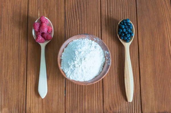 Ingredients for cooking berry cake. Raspberries, blueberries and flour in bowl on dark wooden background — Φωτογραφία Αρχείου