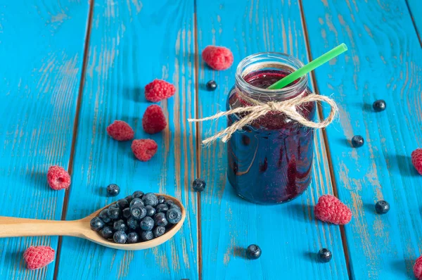 Mason jar with berries jam or marmalade and fresh raspberry, blueberry on a rustic wooden table. Cooking background — Stockfoto