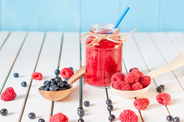 Healthy diet high dietary fiber breakfast with blueberries and raspberries in mason jar on aqua blue rural wooden background. — Stock Photo, Image