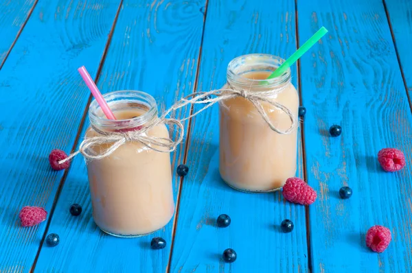 Gezonde baby voedsel appel banaan of abrikoos puree in mason jar, verse frambozen. Lichte landelijke houten achtergrond. Uniek perspectief, selectieve aandacht — Stockfoto