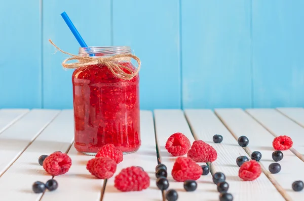 Raspberries jam in mason jar and fresh berries on rural wooden table.  With emty space for text — Stock Photo, Image