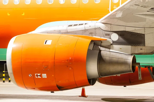 Motorn av flygplan målade i orange. Närbild. Tung teknisk bakgrund — Stockfoto