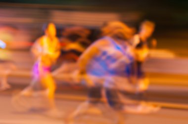 Bulanık sporcular bir yavaş kamera çekim hızı tarafından gece maraton yayınlanıyor. Spor arka plan