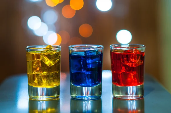 Varios cócteles alcohólicos en un mostrador de bar con luz mágica fondo bokeh — Foto de Stock