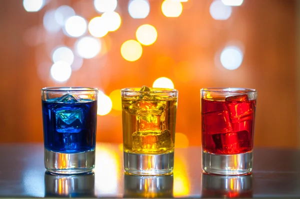 Bebida alcoólica bagas em pequenos copos na mesa de bar com iluminação mágica fundo bokeh — Fotografia de Stock