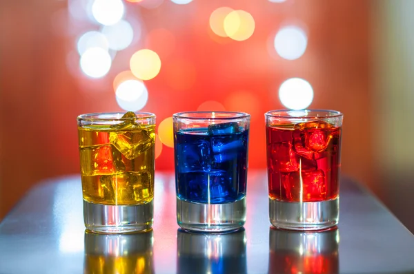 Bebidas alcohólicas brillantes o cóctel de bayas en diferentes colores, vaso de vasos en fondo bokeh luz —  Fotos de Stock