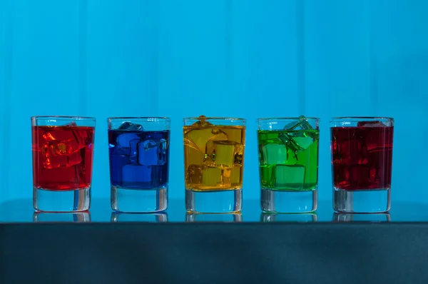 Bright alcohol drinks or berries cocktail in different colours, glasses tumbler on wooden backfround — Stock Photo, Image