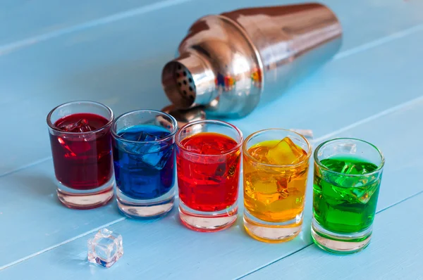 Set of alcoholic cocktails with metal shaker on white bar counter or light background. — Stock Photo, Image