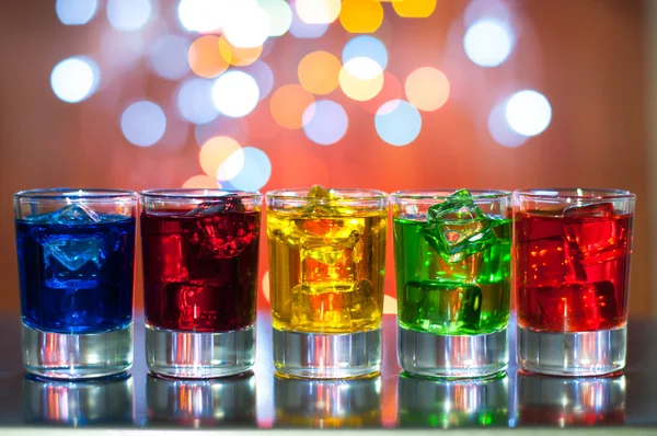 Berry alcoholic drink into small glasses on bar desk with magic illumination bokeh background — Stock Photo, Image