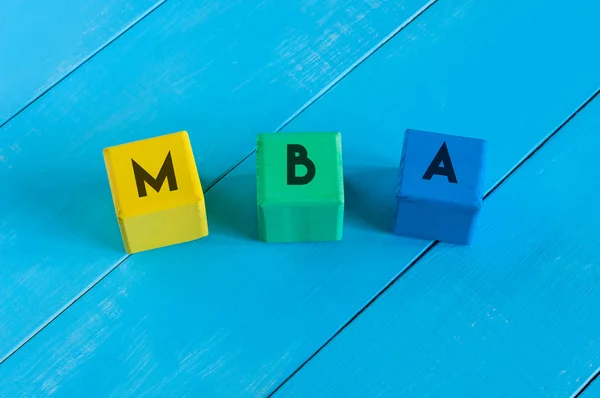 MBA o Master of Business Administration su cubi colorati per bambini con sfondo blu in legno — Foto Stock