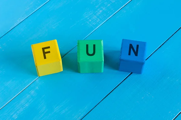 Alfabet bouwstenen dat de spelling van het woord plezier — Stockfoto