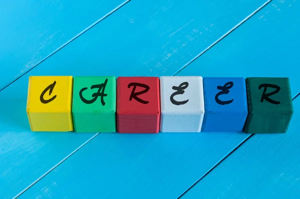 Carrera - palabra en los niños cubos de colores o bloques. Fondo de madera colorido — Foto de Stock
