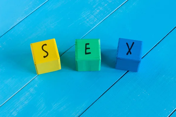 Sex - word on childrens colourful cubes or blocks. Colourful wooden background — Stock Photo, Image