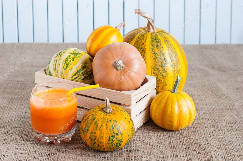 sweet pumpkin smoothies, assortment squashes and pumpkins in wooden crate on white rustic background