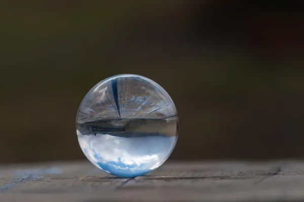 Cristal transparente bola de cristal sobre fondo verde oscuro y superficie de madera. Foco suave. Con espacio vacío para texto — Foto de Stock