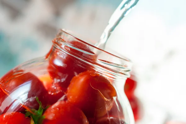 Tomates siendo inundados de agua hervida en proceso de enlatado. Tomate enlatado - buena comida vegetariana de invierno — Foto de Stock