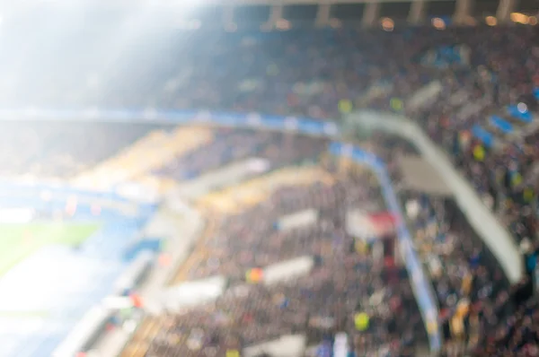 Blurred crowded football stadium. View Of the floodlit tribune of sport arena. Background with empty space for text — Stock Photo, Image