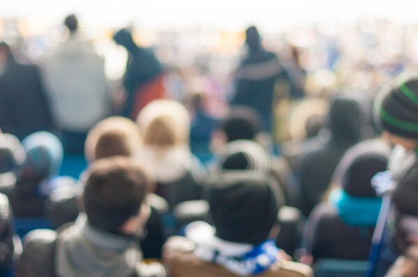Размытая толпа людей на стадионе или в другом населенном пункте, неузнаваемая толпа населения как размытый городской фон

