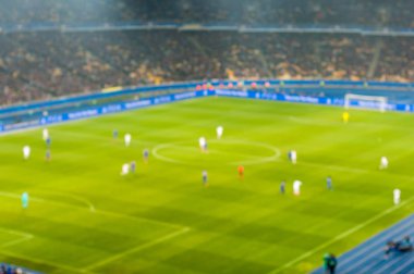 Bulanık futbol ya da futbol oyuncu sahada maç sırasında çalışan. Odak arka plan, metin için boş yer