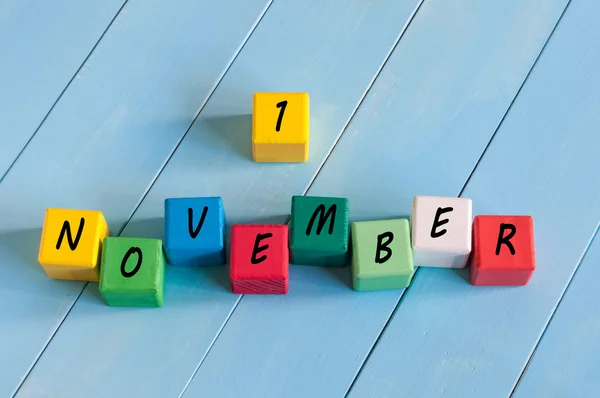 Premier 1er novembre signe sur cubes en bois de couleur avec fond en bois bleu clair . — Photo