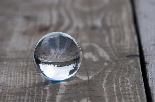 Boule de verre cristal transparent en verre sur fond bois foncé. Concentrez-vous. Avec espace vide pour le texte — Photo