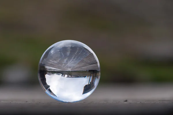 Transparenta kristall glaskula på mörkgrön bakgrund och träytan. Mjukt fokus. Med tomt utrymme för text — Stockfoto