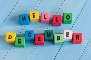 Word Hello December On childs cubes on wooden rural  background.
