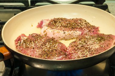 Healthy lean grilled medium-rare beef steak with spice in frying pan. Cooking process. Selective focus