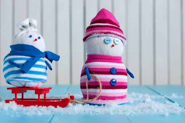 Happy snowman couple in winter sitting with a sled. New year postcard, empty space for text — Stockfoto