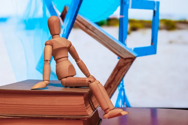 Wooden dummy, mannequin or man figurine sit on book with many blue frames On background — Stock fotografie