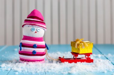Snowman enjoying a sleigh ride with handmade gift boxes. Handmade snowman stay With sledge and Christmas present. Happy Xmas card, empty space