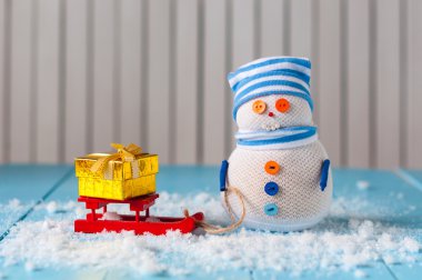 Snowman enjoying a sleigh ride with handmade gift boxes. Handmade snowman stay With sledge and Christmas present. Happy Xmas card, empty space