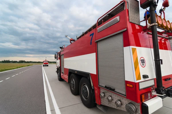 Brandbil eller brandbil på vägen. bakifrån, vidvinkellins. Blå himmel bakgrund — Stockfoto