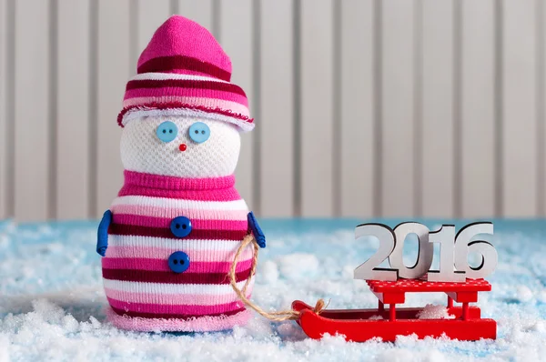 Концепція 2016 року На червоних санях і ручної роботи сніговика на дерев'яному тлі. Різдвяна листівка з порожнім місцем для тексту — стокове фото